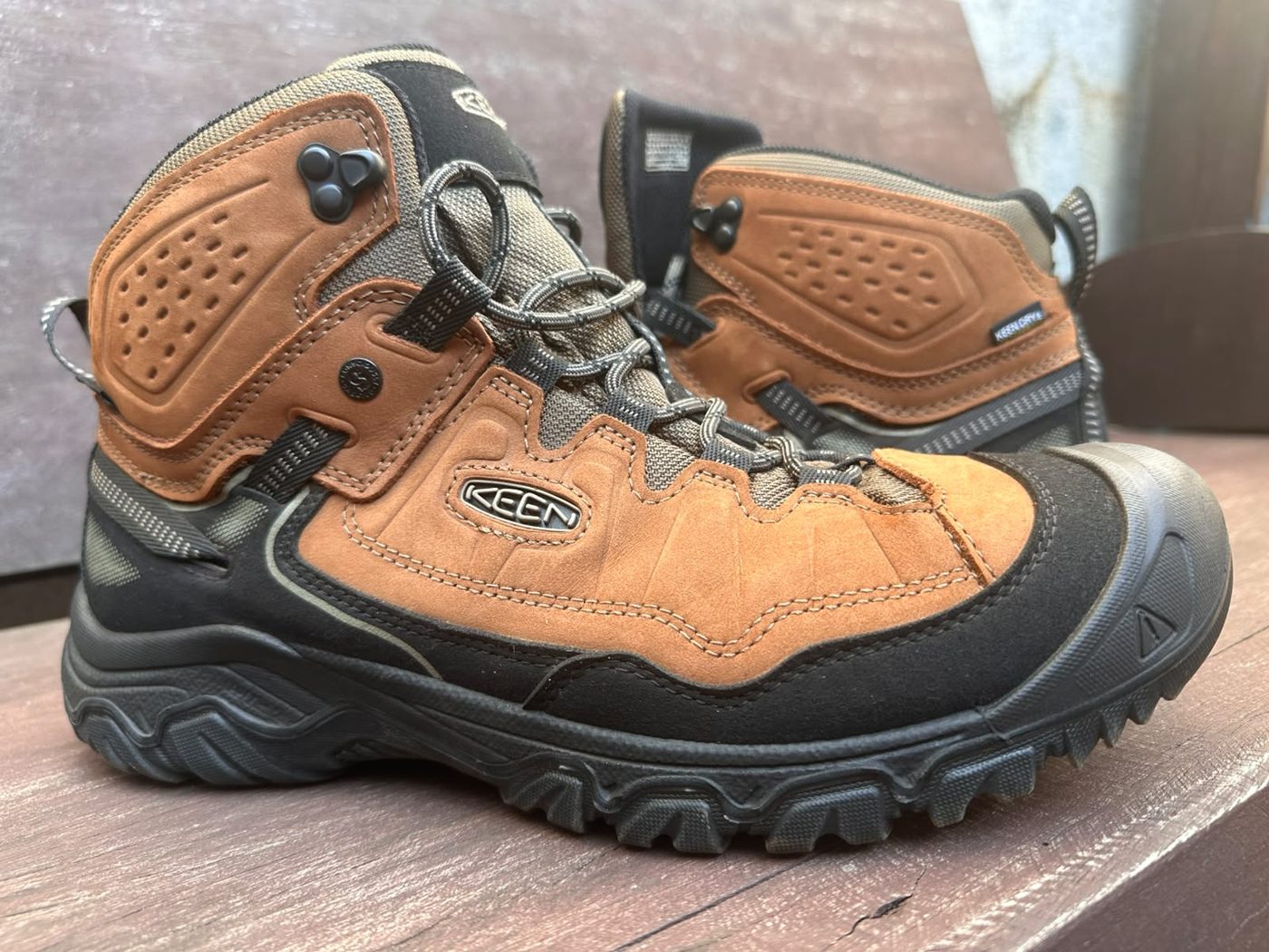 O par da bota KEEN Targhee 4 que usamos, de lado, sobre um banco de madeira